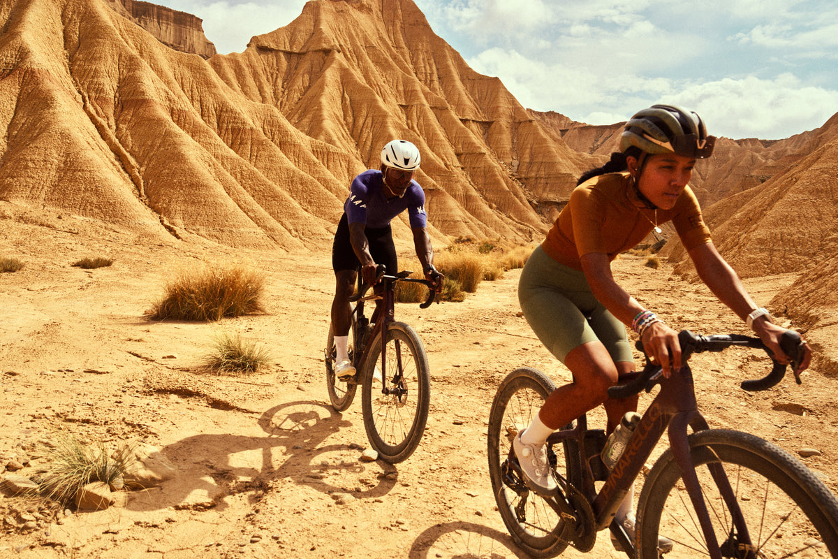 dura2-desert-riders: Two cyclists riding through a desert landscape