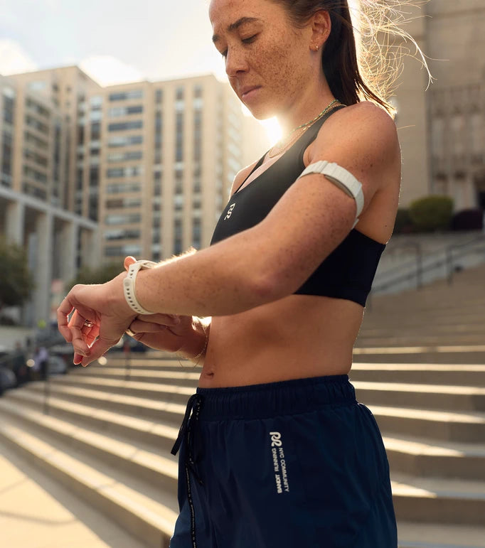 Female runner using media controls on the running watch PACE 4 from COROS
